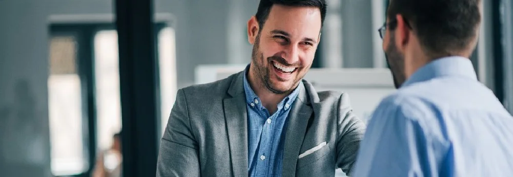 Zwei Geschäftsleute unterhalten sich lachend